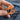 Hand holding Gentlemon Charizard enamel pin.