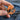 Hand holding Gentlemon Charizard enamel pin.